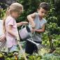 Preview: Kinder Gießen die Pflanzen im Garten grüner rustikaler Hintergrund