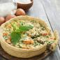 Preview: Frisch gebackener Brennessel Quiche mit Eier Milch und Mehl auf rustikalen Hintergrund