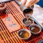 Preview: Japanische Eiserne Teekanne mit 2 Teeschalen und Teesieb rustikaler Hintergrund
