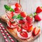 Preview: Frischer Erdbeeren im einem Glas mit Wasser und 2 Strohalme daneben rustikaler Hintergrund