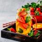 Preview: Glasbecher mit frisch aufgeschnittene Erdbeeren und Orangen rustikaler weißer Hintergrund