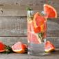 Preview: Grapefruitstücke im einem Wasserglas rustikaler Hintergrund