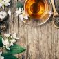 Preview: Jasminblüten mit einer Tasse grünen Tee auf rustikalen Hintergrund