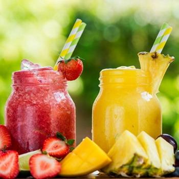 Ananas und Erdbeeren als Shake püriert mit grünen Hintergrund