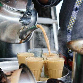 Chai Tee wie er frisch eingeschenkt wird rustikaler Hintergrund