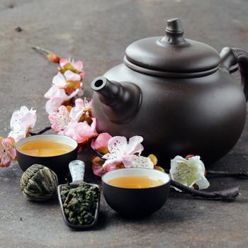 Chinesischer Tee in einer Tonkanne und Tontassen mit rustkalen Hintergrund