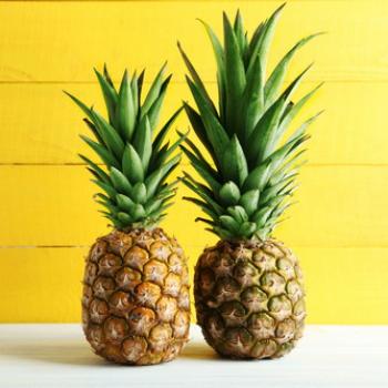 2 Ananas mit gelben rustikalen Hintergrund