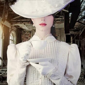 Frau in komplett weißer Kleidung in Vordergrund und Ruine als rustikaler Hintergrund