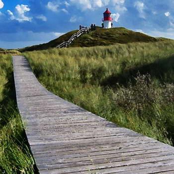 Friesischer Landschaft mit Holzsteg durch die Dünen mit Leuchturm im Hintergrund