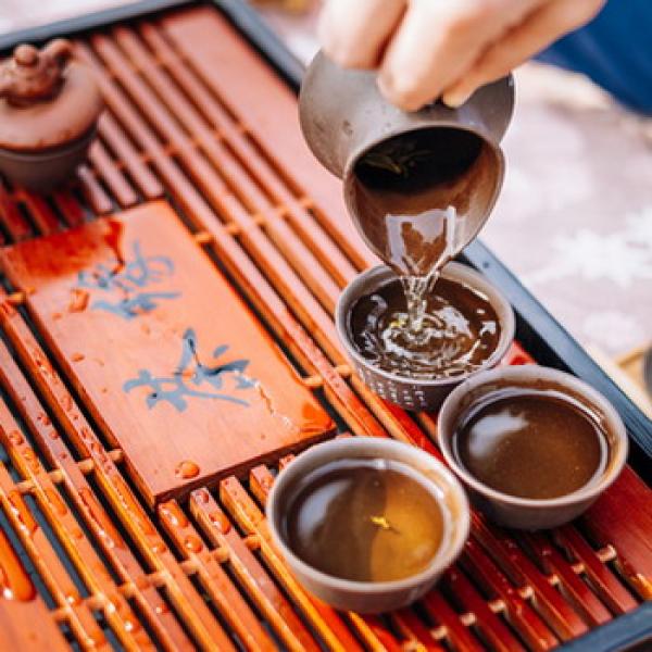 Japanische Eiserne Teekanne mit 2 Teeschalen und Teesieb rustikaler Hintergrund