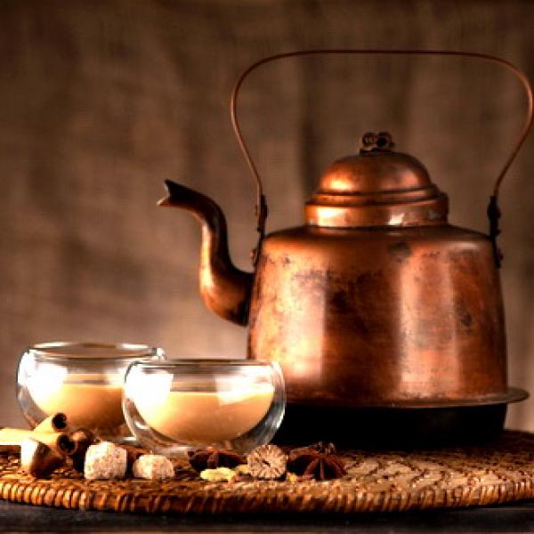 Kesselkanne mit zwei Tassen Tee mit Milch brauner rustikaler Hintergrund