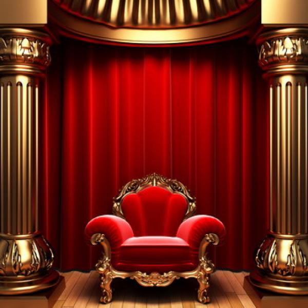 Roter goldener Sessel vor einen roten Vorhang der zwischen zwei golden Säulen steht